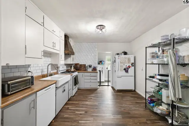 Spacious kitchen with white subway tile backsplash, butcher block counters, and stainless steel appliances.