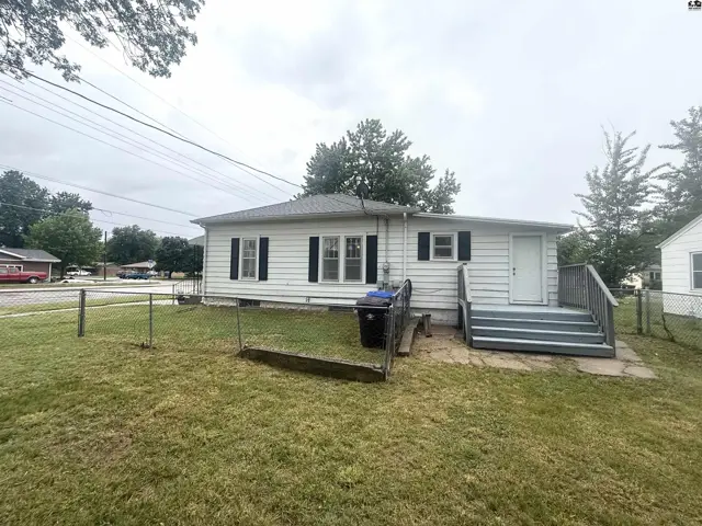 White siding ranch home with a fenced yard and a gray-painted deck.