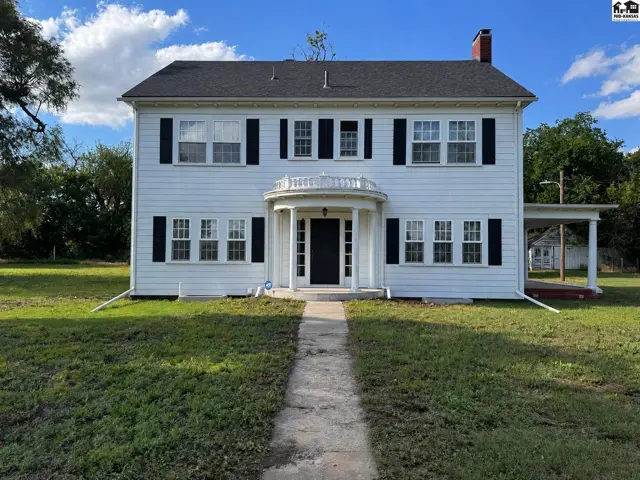 Classic white clapboard two-story home with black shutters and a curved portico entrance.