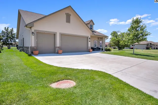 This stucco home features a three-car garage and a covered front porch.