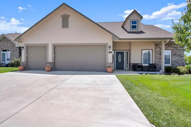 Spacious home features a three-car garage, stone accents, and a welcoming front porch.