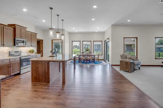 Spacious open-concept living area with a modern kitchen, dining space, and seating area.
