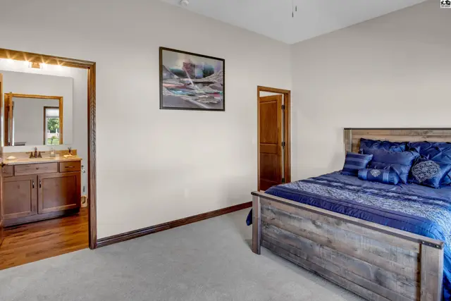 Spacious bedroom with a connected bathroom featuring a wooden vanity.