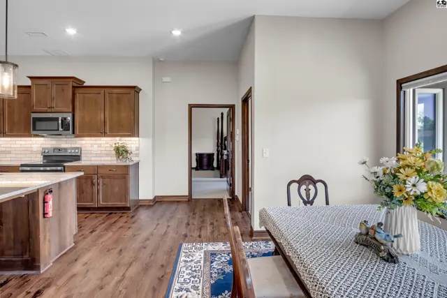 Spacious kitchen with wood cabinetry and granite countertops opens to a dining area.