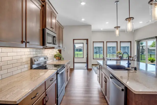 Spacious kitchen features granite countertops, stainless steel appliances, and a large island.
