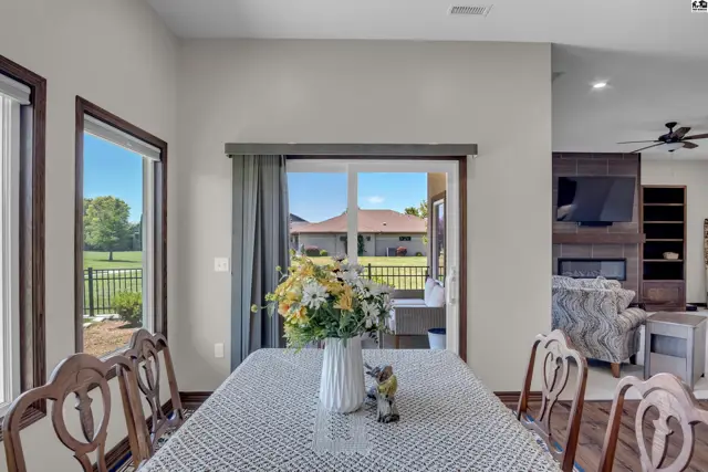 Dining area with a table, chairs, and sliding glass door to the backyard.