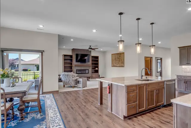 Spacious open-concept living area with a modern kitchen, dining space, and fireplace.