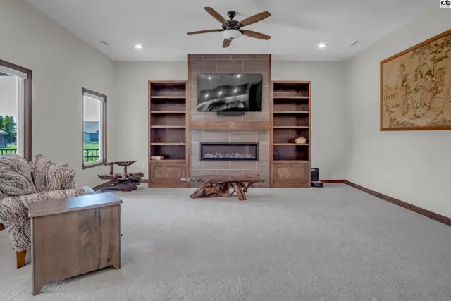 Spacious living room features a built-in entertainment center with a fireplace and ample shelving.