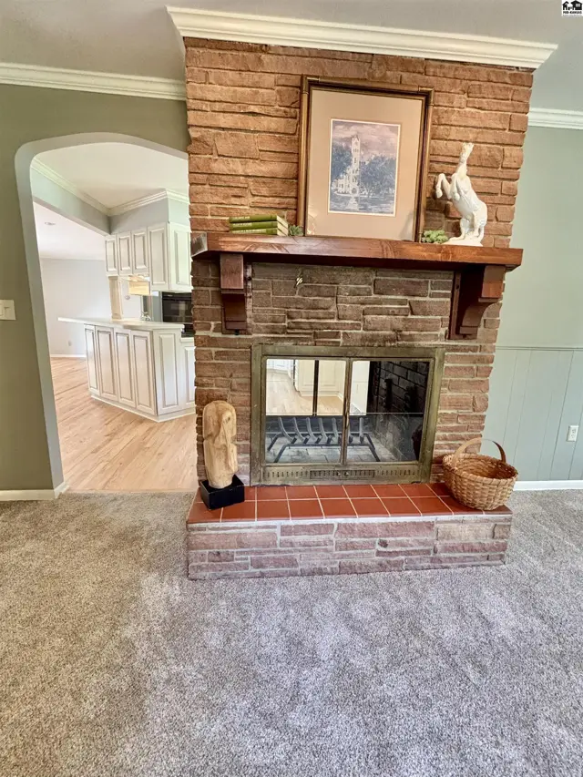 Living room features a rustic stone fireplace with a wooden mantel and a view into the kitchen.