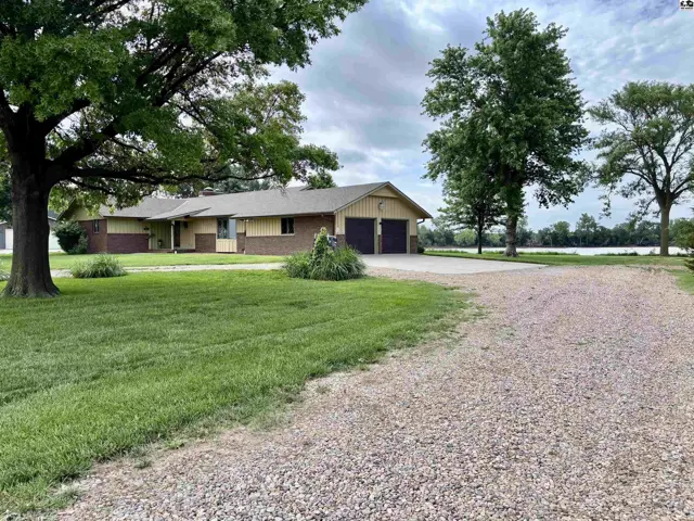 Spacious ranch home with brick accents, attached garage, and scenic water view.