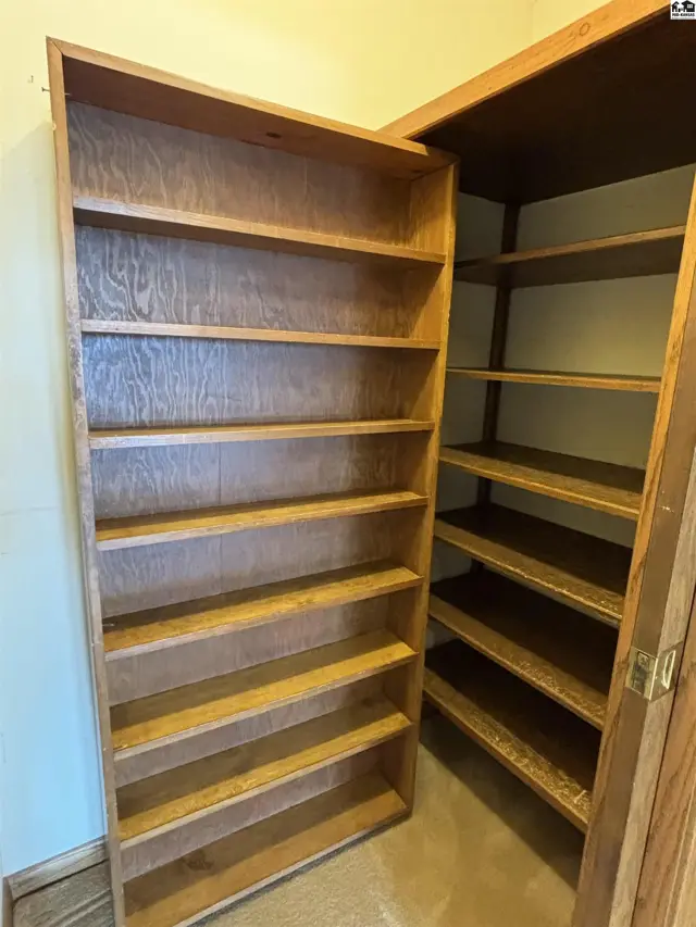 Tall, open oak bookshelves with multiple shelves and a natural wood finish.