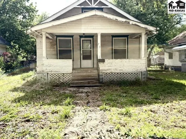 Classic bungalow exterior with a covered front porch, white siding, and lattice skirting.