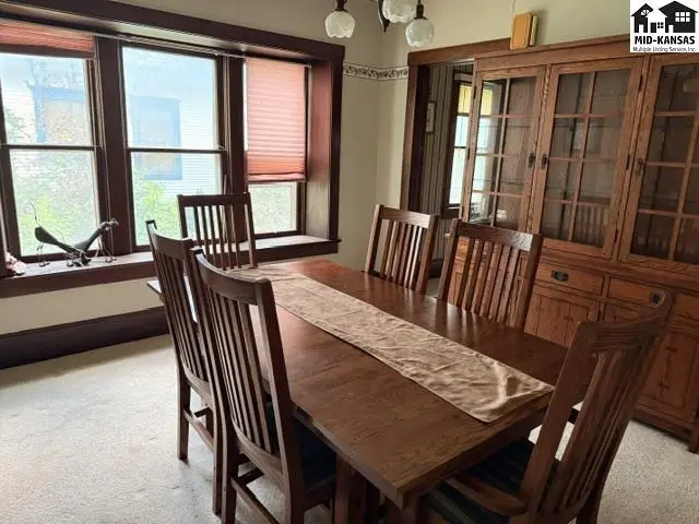Dining room with a large wooden table, chairs, and a built-in china cabinet.