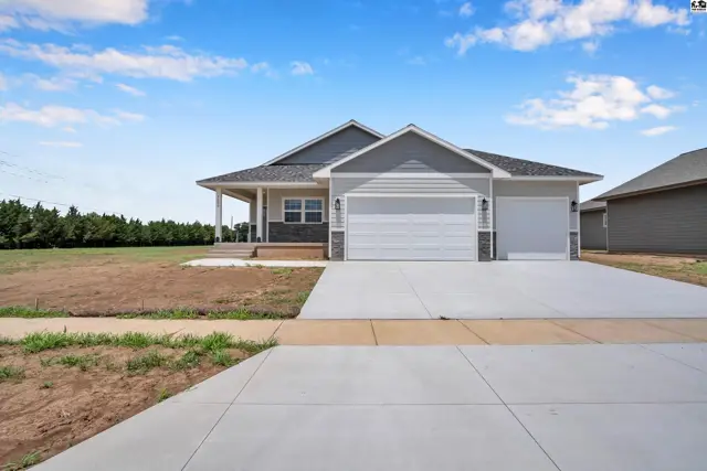 Modern ranch home with gray siding, white garage doors, and a covered front porch.
