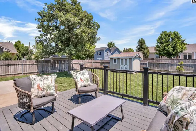 Spacious backyard with a composite deck, seating, and a storage shed.