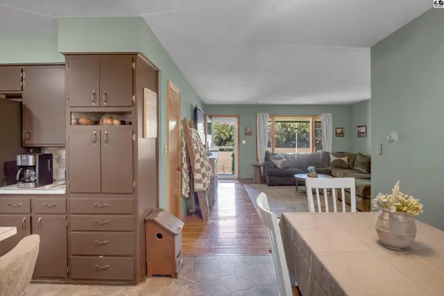 Open living space with a dining area, kitchen cabinets, and a cozy living room.