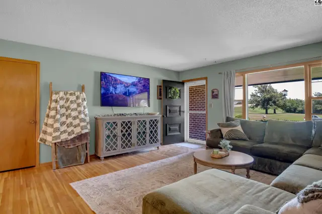 Spacious living room with a sectional sofa, large TV, and a rustic cabinet.