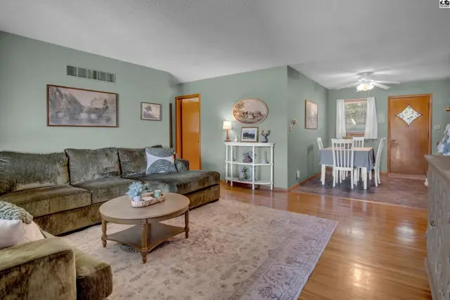 Spacious living room with plush sectional sofa, coffee table, and adjacent dining area with white table and chairs.