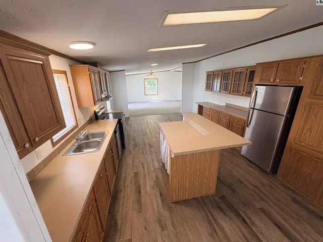 Spacious kitchen with wood cabinets, stainless steel appliances, and a large island with a breakfast bar.