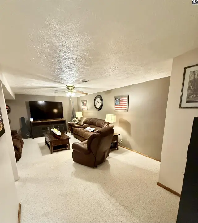 Cozy living room with plush brown leather furniture, a large TV, and neutral walls.