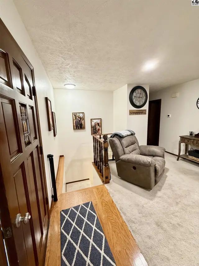 Cozy living room with plush recliner, wood accents, and neutral carpet.