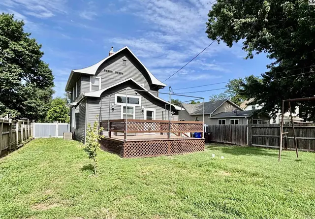 Spacious backyard with a large wooden deck and privacy fencing.