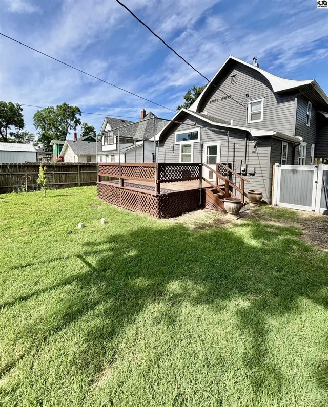 Spacious backyard with a large wooden deck and a fenced area.