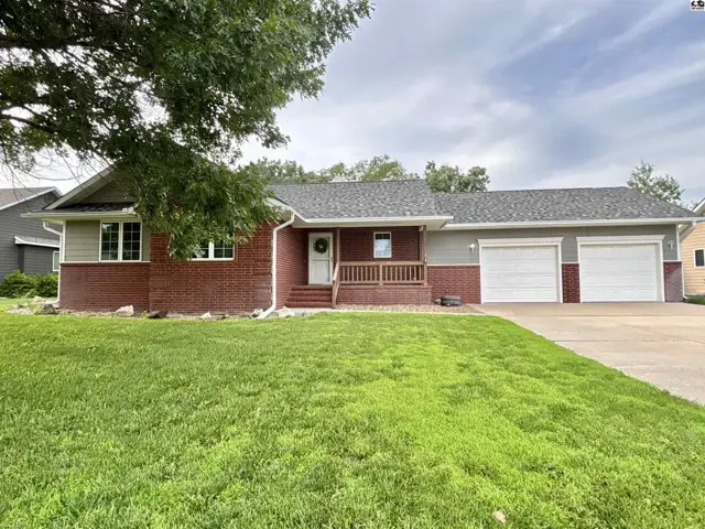Brick and siding ranch home with a three-car garage and a covered front porch.