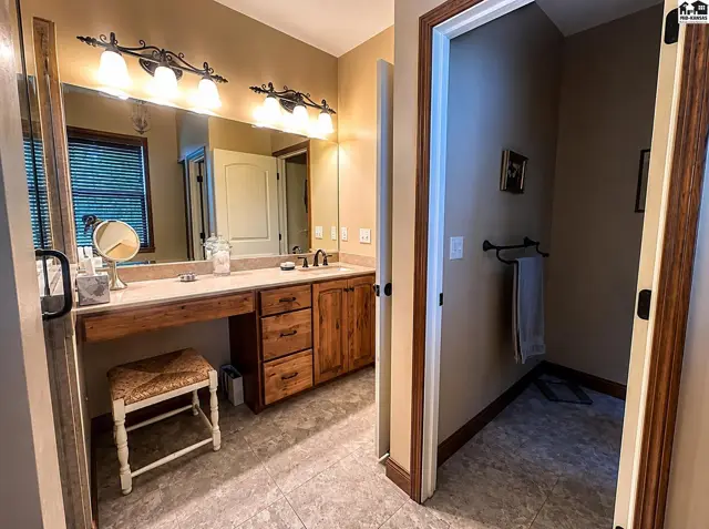 Master bathroom with two separate vanities with sheet glass mirrors, onyx countertops & sinks.