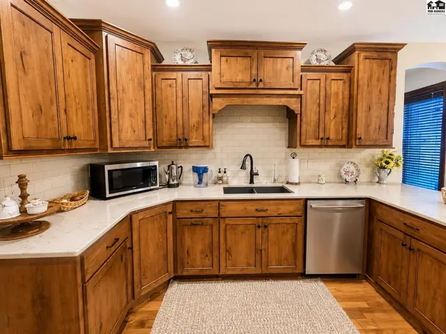 Custom cabinetry, quartz countertops, under cabinet lighting, upgraded appliances, bar and dining.