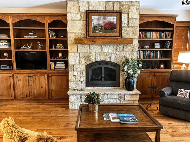 Living room w/beech bookcases flanking, fireplace, wood floors, French doors to screened in porch.