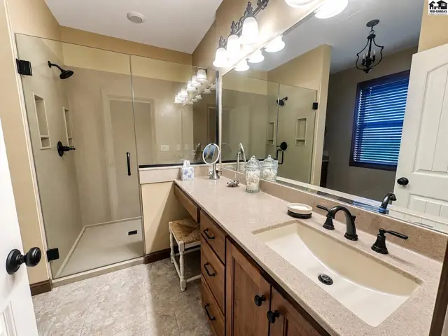 Custom onyx and glass shower with bench seat.