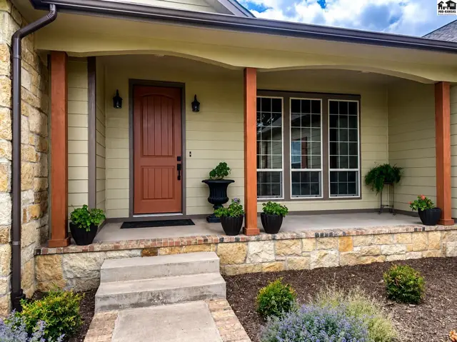 Texas Limestone, brick, concrete siding & cedar posts. Circle drive with Limestone pillars at end.