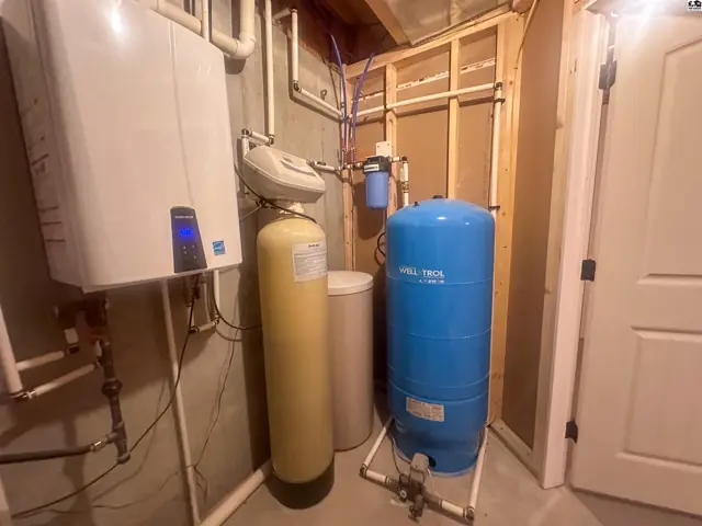Basement utility room with view of water well pressure tank & water filter system & water softener