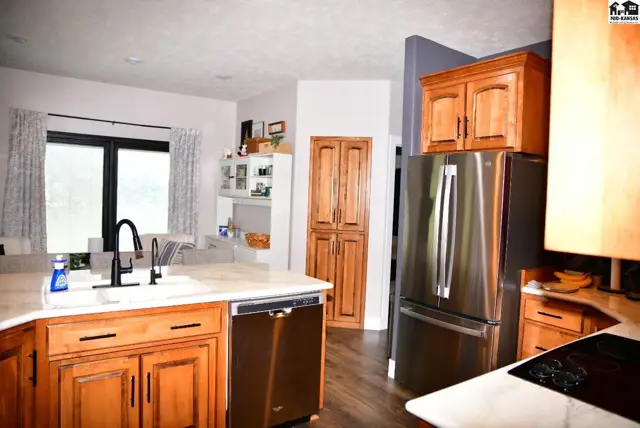 Spacious kitchen with light wood cabinets, stainless steel appliances, and granite countertops.