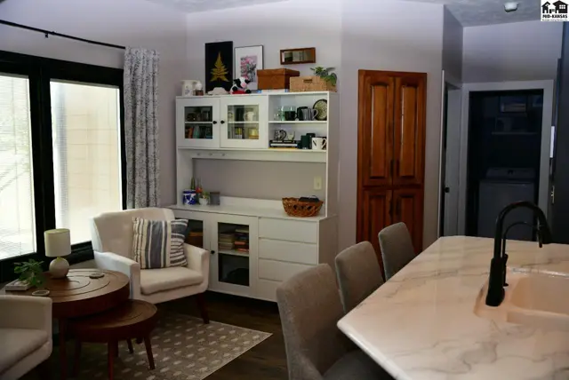 Cozy living area with a white hutch, armchair, and marble-topped island.