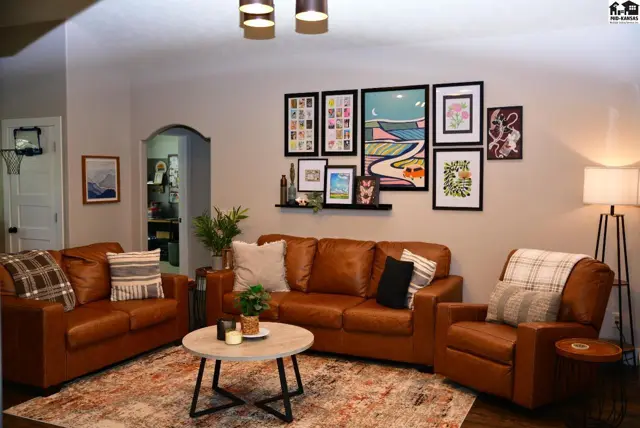 Spacious living room with comfortable leather furniture, a gallery wall, and a modern coffee table.