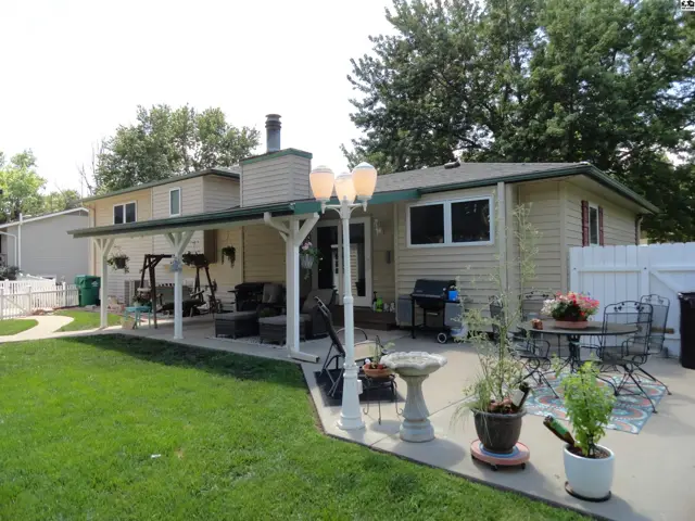 Spacious backyard patio with covered seating area, outdoor dining, and a swing set.