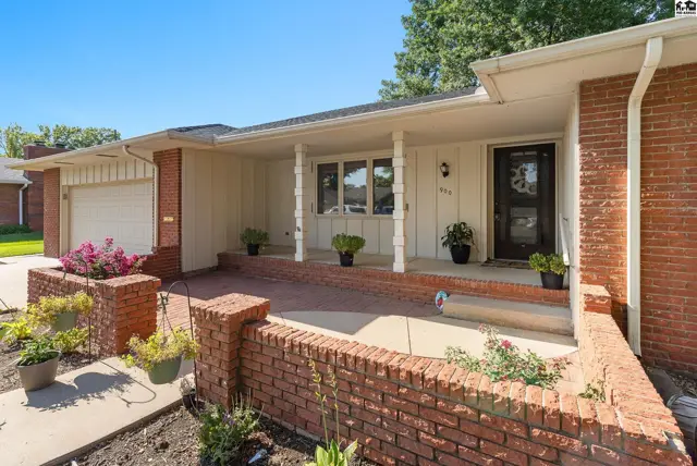 Brick and siding ranch home features a covered porch with white columns and a brick planter.
