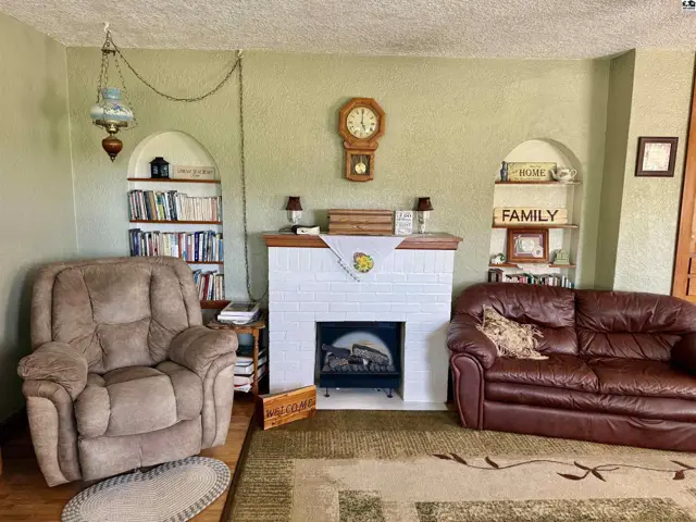 Living room with a white brick fireplace, built-in bookshelves, and comfortable seating.