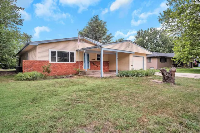 Single-story home with yellow siding, red brick accents, and a covered front porch.
