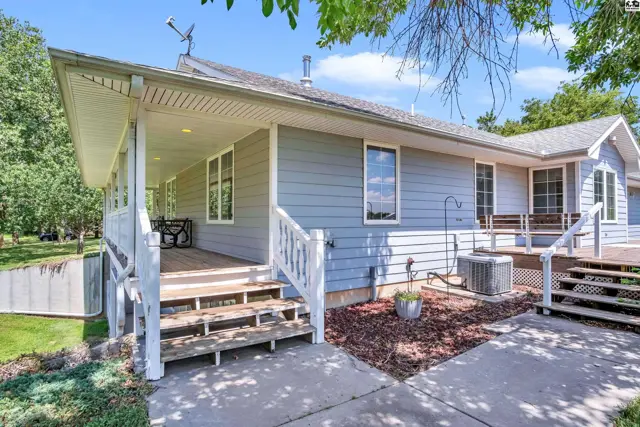 Light blue siding and white railings adorn this home's expansive wrap-around porch and deck.