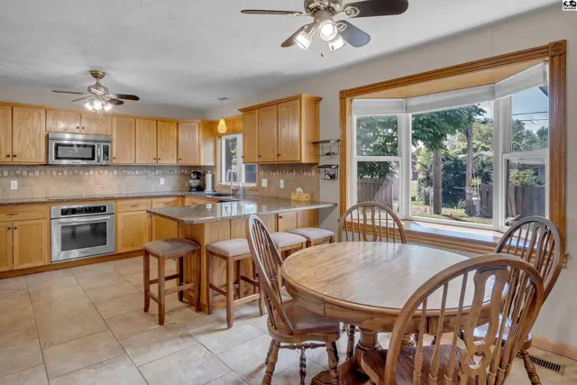 Spacious kitchen with light wood cabinets, granite countertops, and a bay window breakfast nook.