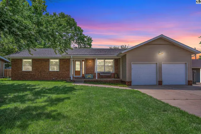Brick and vinyl ranch home with a two-car garage and a covered front porch.