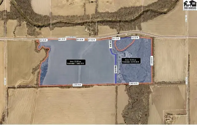 Aerial view shows a large parcel of land with marked boundaries and acreage, bordered by trees and fields.