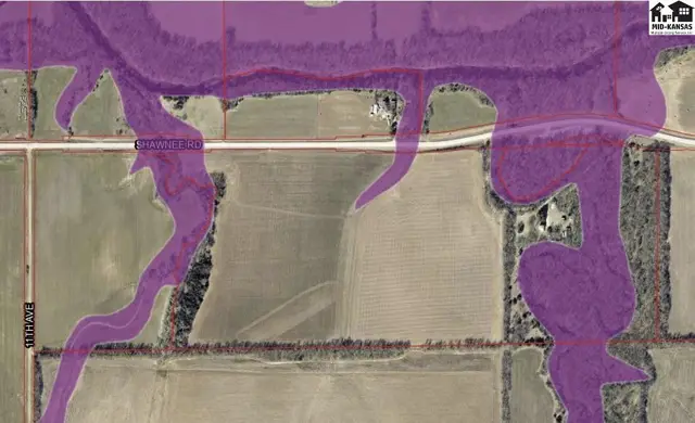 Aerial view shows farmland with purple flood zone overlays along a road and creek.