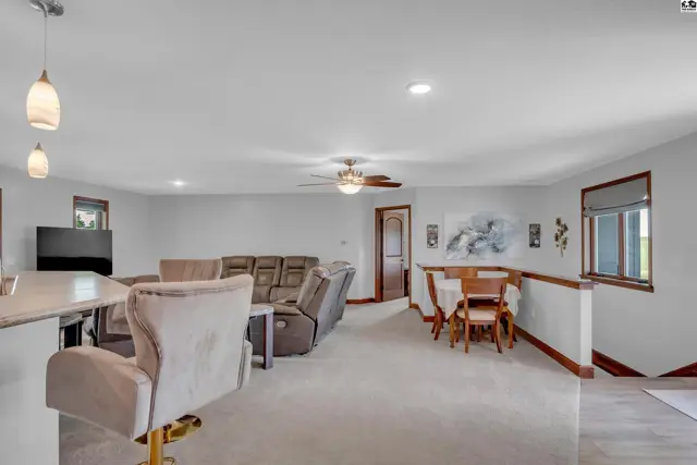 Spacious living area with plush recliner sofa, dining nook, and neutral carpet.