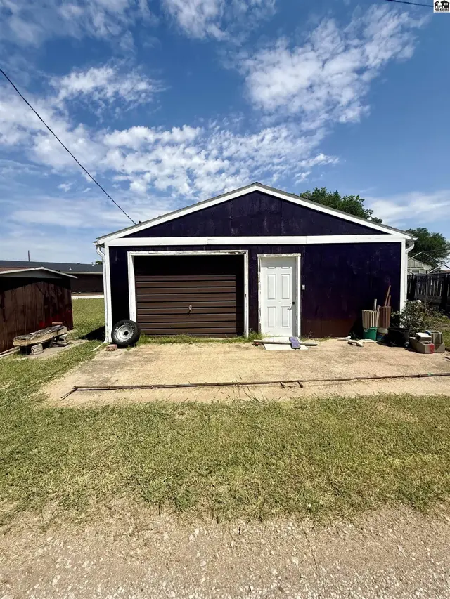 This detached garage features a brown overhead door and a white entry door.