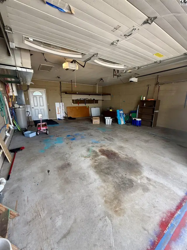 Spacious two-car garage with concrete floor, overhead door, and interior door.