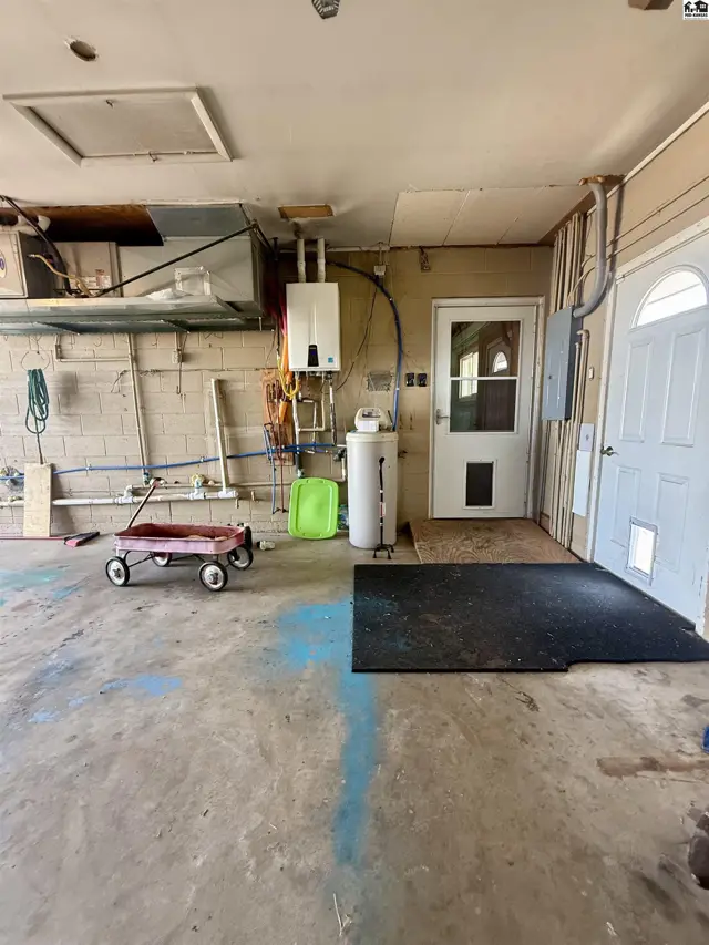 Concrete floor with utility fixtures, doors, and a red wagon.